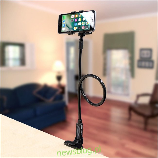 IPhone na stojaku na klips na telefon komórkowy z długim ramieniem Skiva przymocowanym do blatu.