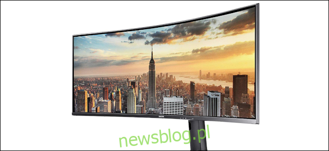 43-calowy ultraszerokokątny monitor Samsung pokazujący panoramę Nowego Jorku o zachodzie słońca.