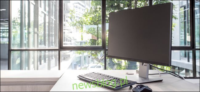 Monitor komputera, klawiatura i mysz na biurku.