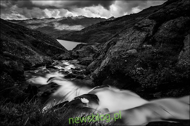 Czarno-białe zdjęcie potoku w górach po deszczu.