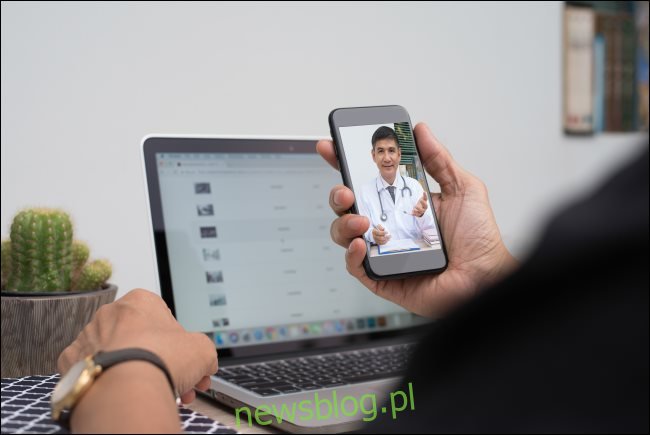 Mężczyzna komunikujący się z lekarzem za pośrednictwem czatu wideo na smartfonie.